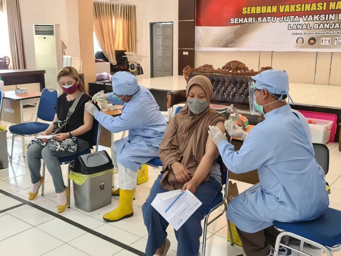 warga sedang dilakukan vaksinasi